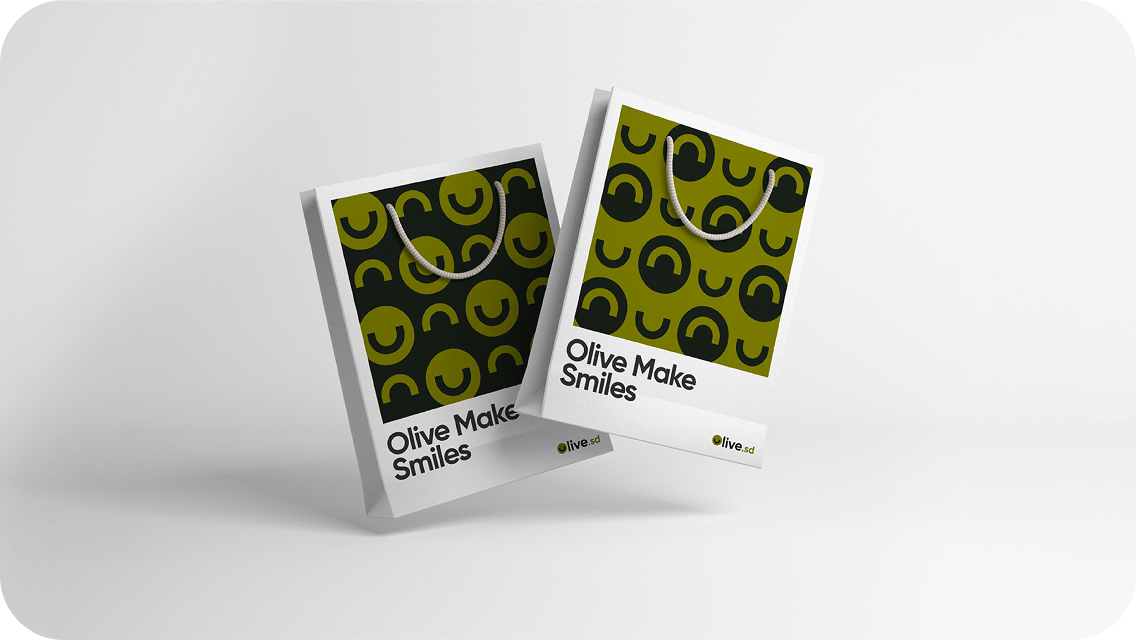 Two branded shopping bags reading Olive Make Smiles